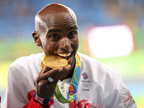 Mo Farah  of Britain bites the gold medal. Reuters