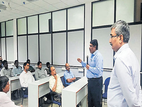N Muthukumar, chairman of CII-Mysuru, interacts with representatives of MSMEs while K P Ashwin, director of  National Productivity Council, looks on during a session in Mysuru recently.