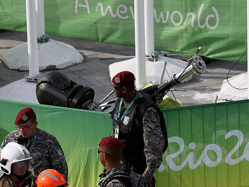 Policemen stand near an overhead television camera that fell and injured two people near the Olympic Park venues for basketball and judo at the Rio 2016 Olympics in Rio de Janeiro, August 15, 2016. REUTERS