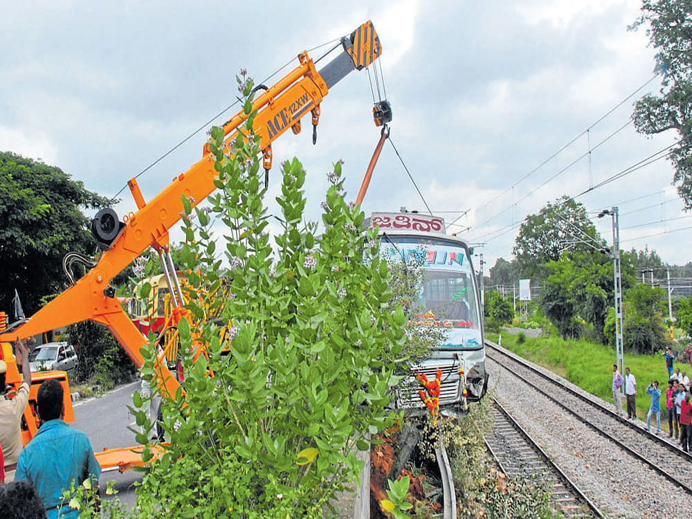 The private bus was lifted by a crane from the railway track at Vaderahalli railway gate near Ramanagaram on Friday. DH photo