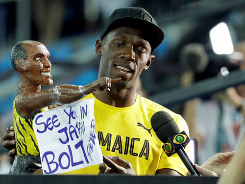 Jamaica's Usain Bolt holds a model of himself as he celebrates winning the gold medal in the men's 4x100-meter relay final during the athletics competitions of the 2016 Summer Olympics at the Olympic stadium in Rio de Janeiro, Brazil, Friday, Aug. 19, 2016. AP/PTI Photo