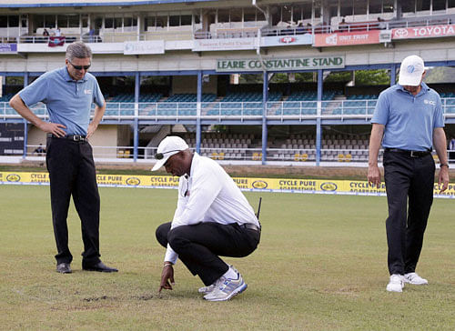Umpires Nigel Llong, left, Gregory Brathwaite, center, and Rod Tucker inspect the field as a wet ground delays the start of day three of the fourth cricket Test match between India and West Indies at Queen's Park Oval in Port-of-Spain, Trinidad, Saturday, Aug. 20, 2016. AP/PTI