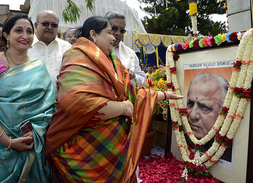 Bharathi Urs (right), daughter of D Devaraj Urs, pays floral tribute to a portrait of the former chief minister on his 101st birth anniversary in Bengaluru on Saturday. DH Photo