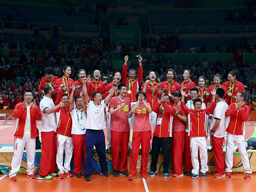 Gold medalist China's (CHN) players and team members pose. REUTERS