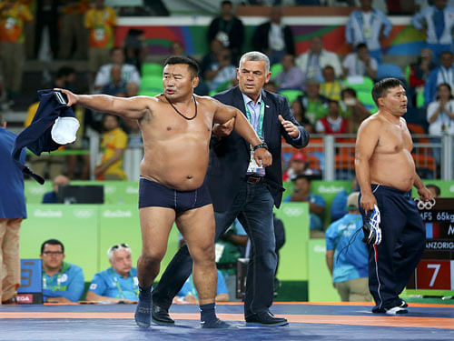 Coaches of Mandakhnaran Ganzorig (MGL) of Mongolia protest against the result of the match with Ikhtiyor Navruzov (UZB) of Uzbekistan by taking off their clothes. REUTERS