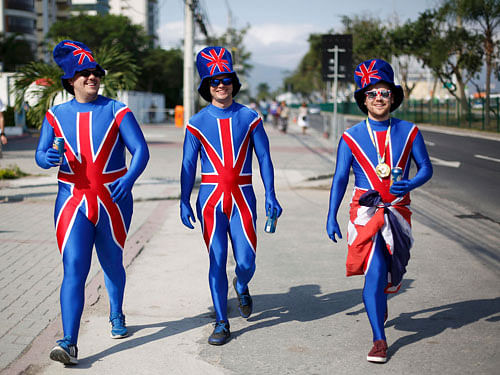 British hockey fans Tom Maers (R) boyfriend of Great Britain player Sam Quek, Michael Bray, brother of GB player Sophie Bray, and friend Greg Lyon (L) walk on their way to watch the women's gold medal match near the Olympic Park. REUTERS