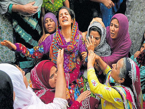 in mourning: Relatives wail over the death of Irfan Fayaz Wani (19),  who was hit by a tear gas shell during a clash on Sunday night, in Srinagar on Monday. PTI