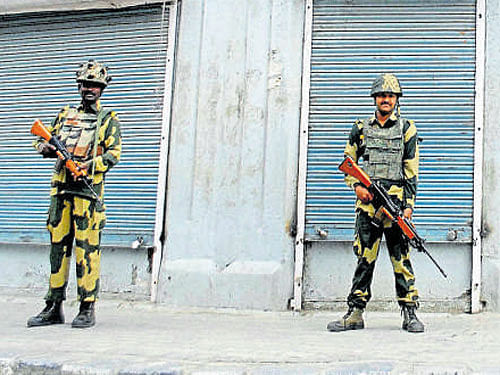BSF jawans guard the streets during curfew in Srinagar on Monday. PTI