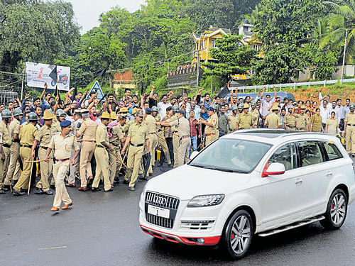 Police disperse BJP yuva morcha workers who staged a protest, hurled eggs and waved black flags as the car carrying actor Ramya came out of the Mangalore International Airport at Bajpe on Thursday. DH Photo