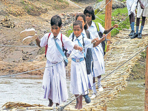 Tough time: Students walk on a bamboo bridge over the Sukri river that was constructed by the villagers near Jaram  village in Latehar in Jharkhand on Wednesday. PTI