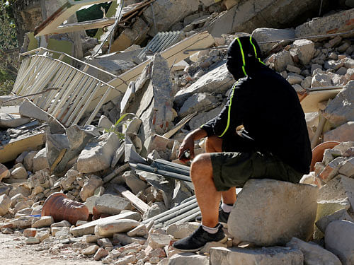 A man sits on the rubble of a collapsed building following an earthquake in Amatrice, central Italy, August 26, 2016. REUTERS photo