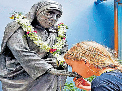 A foreigner prays in front of  Mother Teresa's statue in Kolkata on the occasion of her 106th birth anniversary on Friday. PTI