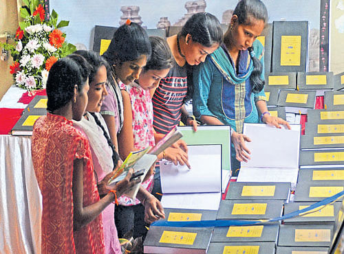 Students take a look at historical documents and photographs displayed at an exhibition at Maharani's College in Bengaluru on Friday. DH PHOTO