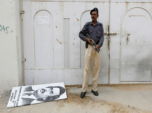 Policeman stands guard at an entrance gate with wax-sealed padlock, beside a poster depicting Altaf Hussain, leader of Muttahida Qaumi Movement (MQM) political party, after paramilitary forces sealed the headquarters in Karachi. Reuters photo
