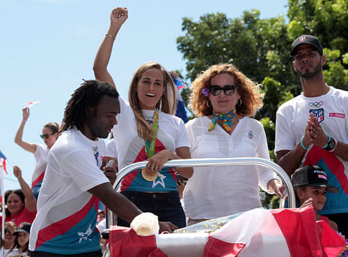 Grand welcome:  Monica Puig (second from left) greets the crowd during her victory parade through the streets of San Juan in Puerto Rico. REUTERS