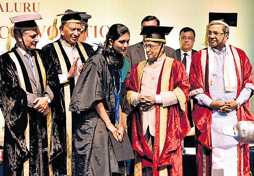 President Pranab Mukherjee has a word with topper Gopika Murthy after conferring gold medals on her at the National Law School of India University convocation in Bengaluru on Sunday. Chief Justice of India T S Thakur, Governor Vajubhai Vala and Chief Minister Siddaramaiah are seen.
