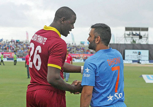 West Indies' Carlos Brathwaite (26) shakes hands with India's MS Dhoni (7) after the second Twenty20 international cricket match was called off due to rain, Sunday, Aug. 28, 2016, in Lauderhill, Fla. The West Indies won the two-match series 1-0. AP/PTI