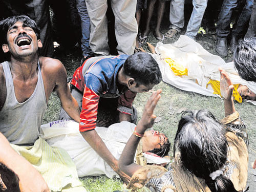 Grieving family members mourn the death of their children after consuming mid-day meal at a school at Dharmasati Gandaman village in Saran District of Bihar state. FILE PHOTO