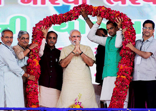 Prime Minister Narendra Modi and Gujarat CM Vijay Rupani being garlanded by BJP workers during the inaugural function of the first phase of Saurashtra Narmada Avataran for Irrigation (SAUNI) project in Rajkot on Tuesday. PTI Photo