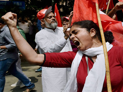 Woman trade union worker shouts slogans during the nationwide strike against central government in New Delhi on Friday. PTI Photo