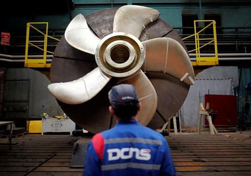 An employee looks at the propeller of a Scorpene submarine at the industrial site of the naval defence company and shipbuilder DCNS in La Montagne near Nantes, France, April 26, 2016. REUTERS