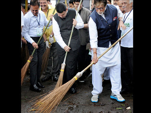 Bollywood superstar Amitabh Bachchan and Chief Minister of Maharashtra Devendra Fadnavis sweeping the streets during the 'Maha Cleanathon' at JJ Hospital in Mumbai on Saturday. PTI Photo
