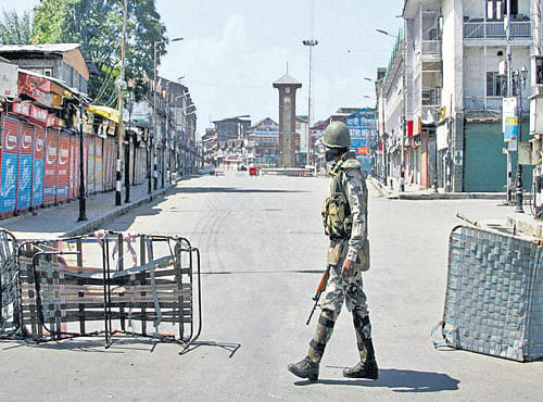 KEEPING AN EYE:Ajawan patrols a blocked road during the 58th day of curfew in Srinagar on Sunday. PTI