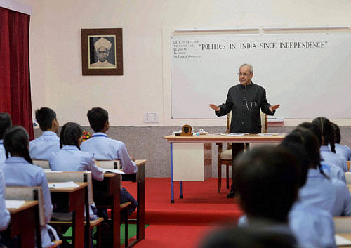 President Pranab Mukherjee teaching students in a class at a Government School on the occasion of Teacher's Day in New Delhi on Monday. PTI Photo / RB