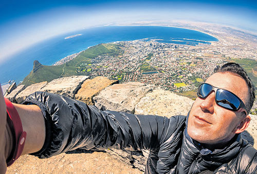 travel diaries: A man taking a selfie at Table Mountain in Cape Town, South Africa. When people talk about how the internet has changed the way we travel, they typically lament the way our compulsion to document removes us, somehow, from the actual experience.
