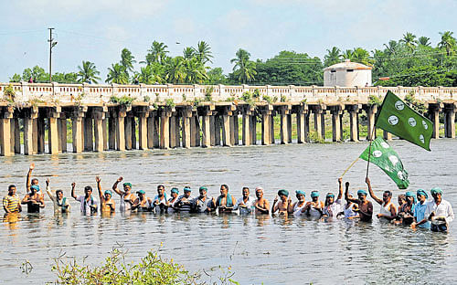 up in arms: Farmers enter into the Cauvery near Wellesley Bridge at Srirangapatna in Mandya district on Wednesday and stage a protest against the Supreme Court order to release water to  Tamil Nadu. dh Photo