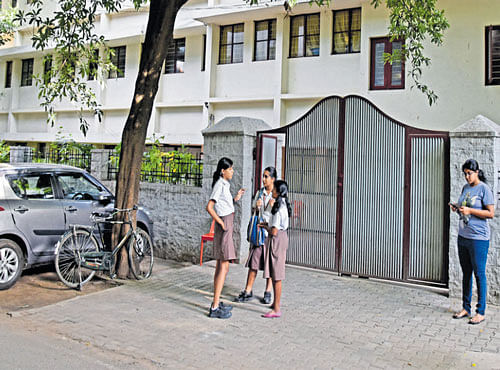 Students stand outside the National Public School, Indiranagar, in Bengaluru on Wednesday. DH PHOTO