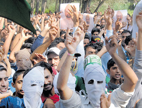 unrest prevails: Protesters shout slogans while carrying photographs of Hurriyat  chairman Mirwaiz Umar Farooq  during a rally in Srinagar on Saturday. PTI