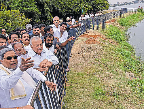 Chief Minister Siddaramaiah, Transport Minister Ramalinga Reddy and others at a programme to launch the work on  creating a biodiversity park at the Madiwala lake on  Monday. dh photo