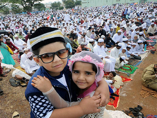 : Muslim children greet eachother as other offer Namaz on the occasion of Eid-al-Adha in Mysuru on Tuesday. PTI Photo
