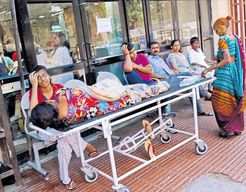 Patients wait outside RML hospital in New Delhi on Tuesday. PTI