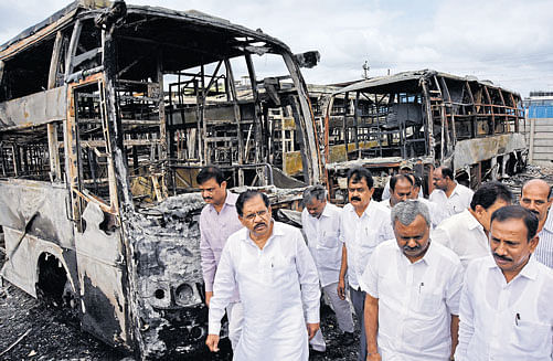 Home Minister G Parameshwara (second from left) and officials on Wednesday inspect the KPN bus depot at D'Souza Nagar in Bengaluru, which was set on fire by arsonists. MLAs Munirathna (extreme left ) and S T Somashekar (second from right) accompanied him. DH photo