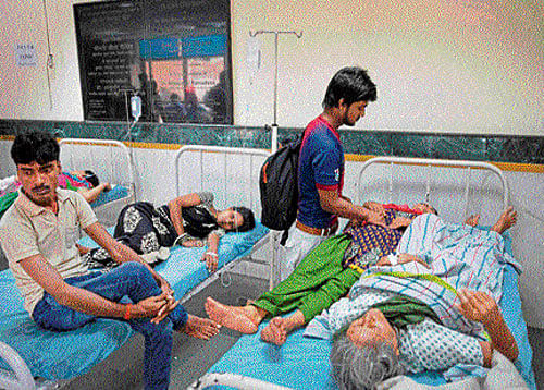 Patients share a bed at Ram Manohar Lohia hospital in New Delhi on Thursday. PTI
