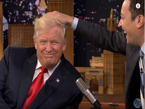 Fallon reached out with his right hand and mussed Trump's hair with a vigorous, repeated rub. The Republican nominee endured it with a broad smile. Screengrab