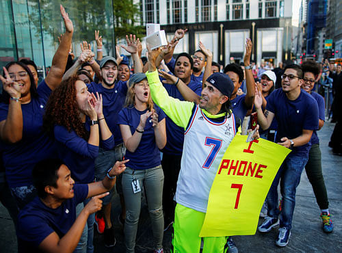 Jaime Gonzalez (C) celebrates with Apple workers after buying the iPhone 7 smartphone outside an Apple Inc. store in New York, U.S., September 16, 2016. REUTERS