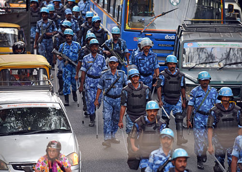 Rapid Action Force personnel stage a march on Mysuru Road on Monday evening. DH Photos