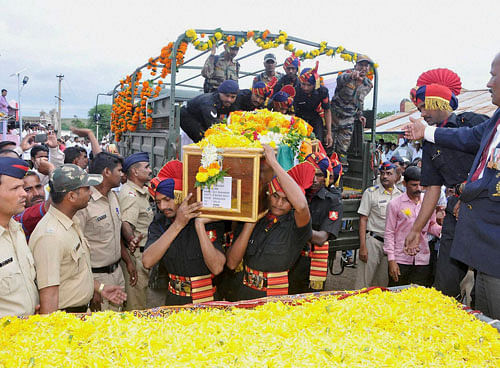 Army jawans carry the coffin of Lance Naik Chandrakant Shankar Galande who was martyred in Uri attack, during his cremation ceremony at Jashi Village in Satara, Maharashtra on Tuesday. PTI Photo