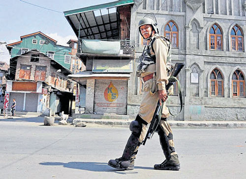 A soldier holding a pellet gun stands guard in Srinagar on Thursday. PTI