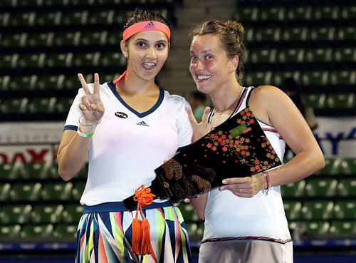 Sania Mirza, left, of India, and her doubles partner Barbora Strycova, of the Czech Republic, pose with their champion trophy during the award ceremony for the women's doubles at the Pan Pacific Open women's tennis tournament in Tokyo, Saturday, Sept. 24, 2016. AP/PTI
