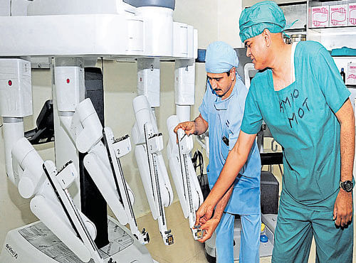 Dr Ramachandran (left) checks the Robotic Computer Console from which the Robotic Arm (Da Vinci Surgical System) can be controlled, at Kidwai Memorial Institute of Oncology in Bengaluru on Saturday. DH PHOTO
