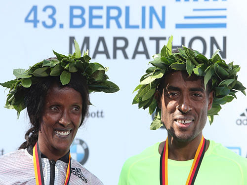 Winners Kenenisa Bekele (R) of Ethiopia and Aberu Kebede of Ethiopia celebrate during the victory ceremony at the Berlin marathon in Berlin, Germany. Reuters Photo.