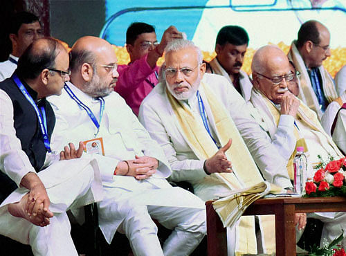 Prime Minister Narendra Modi interacts with Finance Minister Arun Jaitley and BJP President Amit Shah during BJP's National Council Meeting at Kozhikode on Sunday. Senior leader LK Advani is also seen. PTI Photo
