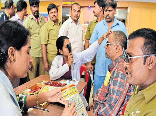 Drivers of educational institutions in Yelahanka undergo eye test during a workshop on drunk-driving, organised by the Yelahanka RTO on Sunday. DH PHOTO