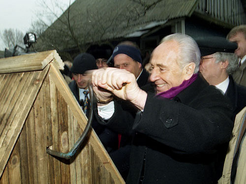 Shimon Peres tries a well during his visit in Belarussian village of Vishnevo, Belarus January 15, 1998. Photo taken January 15, 1998. Reuters
