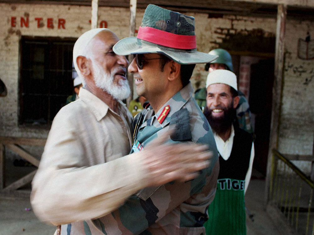 Col. Dharmendra Yadav embraces an Imam at Rainpora in Anantnag district during Operation 'Calm Down' of the Army. PTI photo