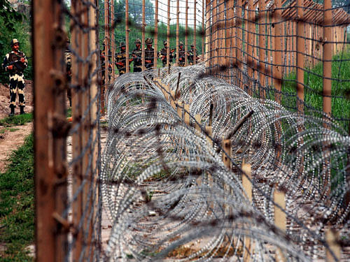 Border Security Force (BSF) soldiers patrol near the fences at the India-Pakistan International Border at Dewali post of Akhnoor sector on Tuesday. PTI Photo